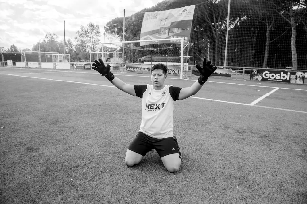 Atleta da NEXT comemorando de braços abertos no gramado
